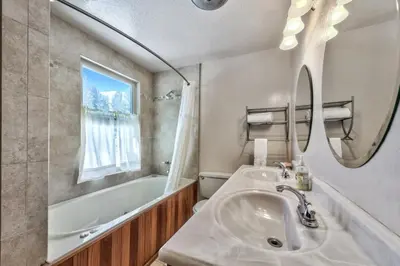 a bathroom with a sink and a tub and a mirror at Tall Pines in South Lake Tahoe