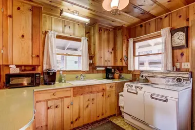 a kitchen with wooden cabinets and a white stove top oven at 3993C Cedar Cabin Lake Tahoe in South Lake Tahoe