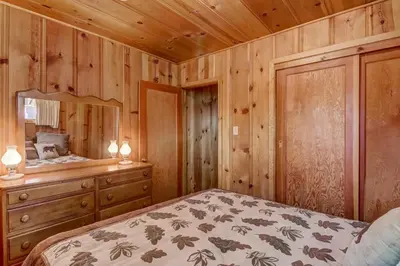 a bedroom with a bed and a wooden wall at 3993C Cedar Cabin Lake Tahoe in South Lake Tahoe