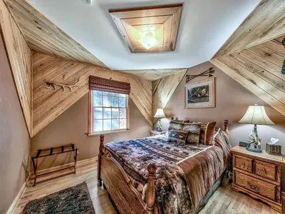 a bedroom with a large bed and wooden ceilings at 2556H Lazy Bear's Den in South Lake Tahoe