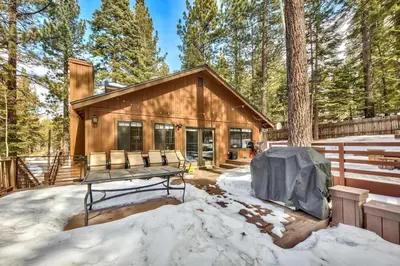 a log home in the woods in the snow at 1760T Thunderbird Cabin in South Lake Tahoe