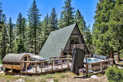a cabin in the woods with a hot tub and a house at 3001R Reindeer A Frame Cabin in South Lake Tahoe