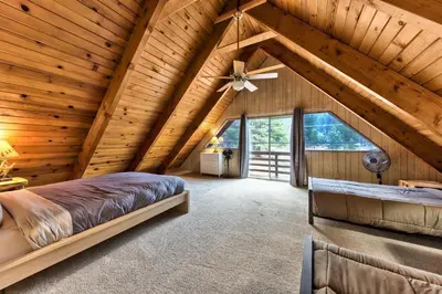 a bedroom in a log cabin with a ceiling fan at 2782B Tahoe River Chalet in South Lake Tahoe