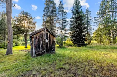 an old out house in a field with trees at 2782B Tahoe River Chalet in South Lake Tahoe