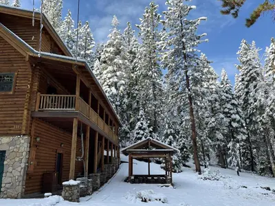 a log cabin in the snow next to some trees at Tahoe Moose Lodge 1170AC in South Lake Tahoe