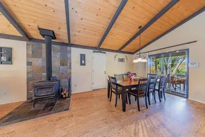 a dining room with a table and a wood stove at Yosemite Wooded Hills, Pool Table, Fitness, Views in Oakhurst