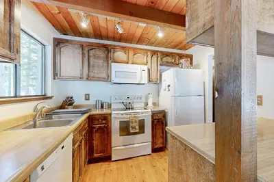 a kitchen with wooden cabinets and a white refrigerator at Less Than 2 Mi to Tahoe Donner Ski Resort Serene Retreat in Armstrong