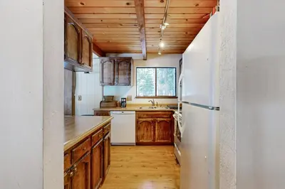 a kitchen with wooden cabinets and a white refrigerator at Less Than 2 Mi to Tahoe Donner Ski Resort Serene Retreat in Armstrong