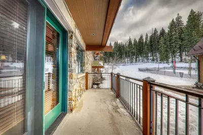 a balcony of a house with a view of the snow at Big Horn Lodge 202 by East West Hospitality in Truckee