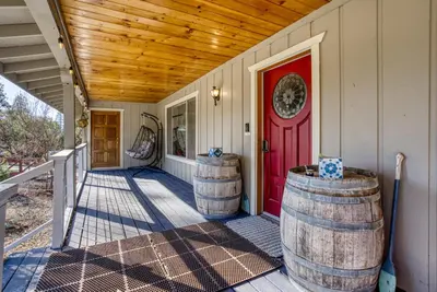 a house with two barrels on the front porch with a red door at Mariposa home, Yosemite retreat, deer watching, family friendly in Mariposa