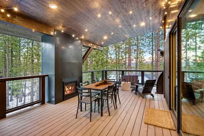 a deck with a table and chairs and a fireplace at Luxurious Truckee Rental Hot Tub and Valley Views in Truckee