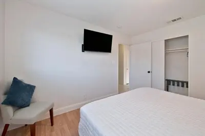 a bedroom with a bed and a chair and a television at Arden Calexpo HotTub Pool Firepit BBQ NoPetFee in Sacramento