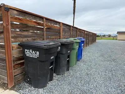 a row of trash cans lined up against a fence at GUEST RANCH HOUSE w POOL access near NATL PARKS in Dinuba