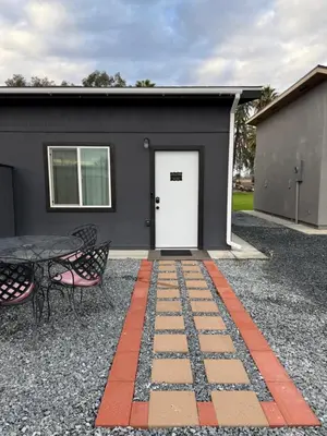 a building with a white door and a table and chairs at GUEST RANCH HOUSE w POOL access near NATL PARKS in Dinuba