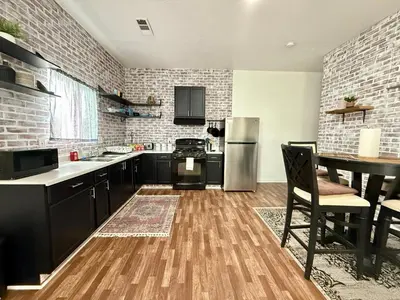 a kitchen with black cabinets and a stainless steel refrigerator at GUEST RANCH HOUSE w POOL access near NATL PARKS in Dinuba