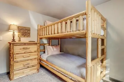 a log cabin bedroom with a bunk bed and a dresser at Miztec Mountain - Ping pong & basketball hoop game in South Lake Tahoe