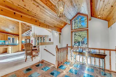 a living room with a wooden ceiling and a staircase at Spacious Tahoe City Home with Foosball and Lake Views in Tahoe City