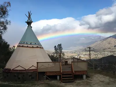 a rainbow in the sky over a teepee at Big Glamping Teepee in Bodfish