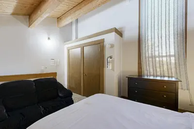 a bedroom with a bed and a dresser and a window at The Cozy Condo in Kingswood Estates