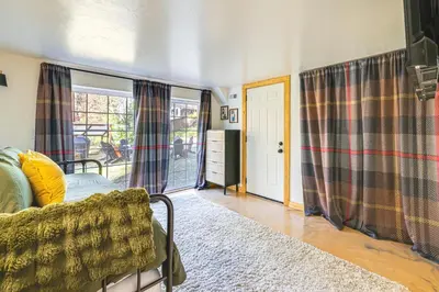 a living room with a couch and a sliding glass door at Walk to Golf, Lake Twain Harte Cabin with Fireplace in Twain Harte