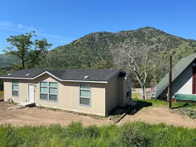 a house with a mountain in the background at Brand New Scenic Sequoia House in Three Rivers