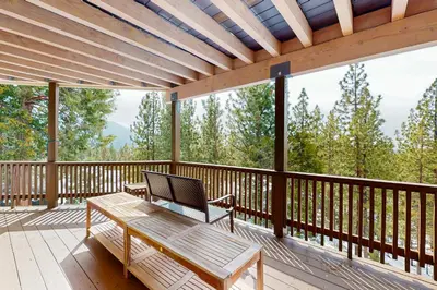 a wooden deck with a bench and a table on it at Cliffside Retreat in Zephyr Cove