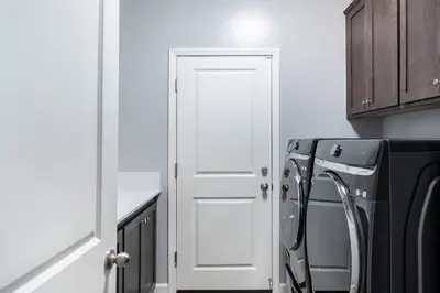 a white door in a kitchen next to a washing machine at Spacious 4BR Home With BBQ, Near Sequoia & Fresno in Hanford
