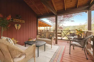 a screened in porch with chairs and a table at 10-acre Forest Villa, 20 miles from Yosemite South in Oakhurst