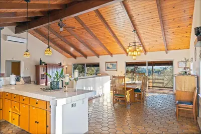a kitchen with wooden ceilings and a dining room at 10-acre Forest Villa, 20 miles from Yosemite South in Oakhurst