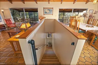 a staircase in a living room with a stair case at 10-acre Forest Villa, 20 miles from Yosemite South in Oakhurst