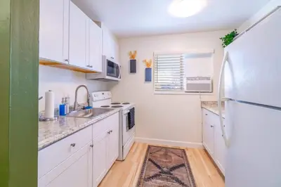 a kitchen with white cabinets and a white refrigerator at Emerald Escape - UNR & Pet Friendly in Reno