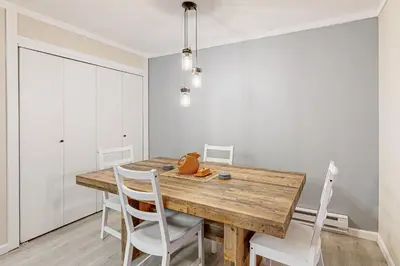 a dining room with a wooden table and white chairs at Lakeside Life in Tahoe Vista