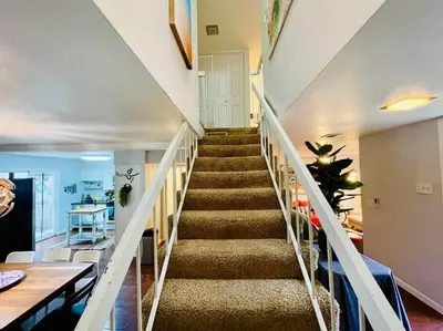 a staircase in a living room with a stair case at Artist's Condo with 2 Bedroom & Arcade in Sacramento