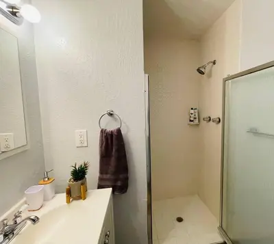 a bathroom with a shower and a sink and a mirror at Artist's Condo with 2 Bedroom & Arcade in Sacramento