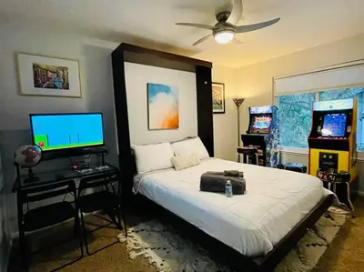 a bedroom with a bed with a television and a bed sidx sidx sidx at Artist's Condo with 2 Bedroom & Arcade in Sacramento