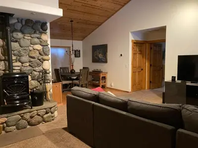a living room with a couch and a stone fireplace at Cozy 3 bedroom home in Tahoe Donner in Truckee