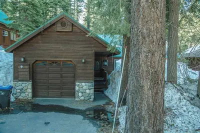 a large wooden garage with a tree in front of it at Cozy 3 bedroom home in Tahoe Donner in Truckee
