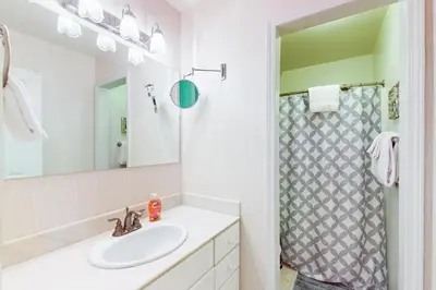 a white bathroom with a sink and a shower at Wildwood Wonder in South Lake Tahoe