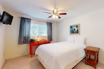 a bedroom with a white bed and a ceiling fan at Wildwood Wonder in South Lake Tahoe