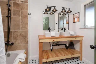 a bathroom with a sink and a mirror at Yosemite Lookout Lodge w/ hot tub, firepits, game room, and more in Oakhurst