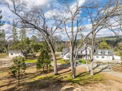 an aerial view of a house with trees at Cedar Creek Lodge with POOL/hot tub/sleeps 24 in Oakhurst