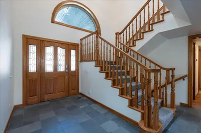 a staircase in a home with a wooden door at Greystone Manor- HUGE home with sleeping for 21 in Oakhurst