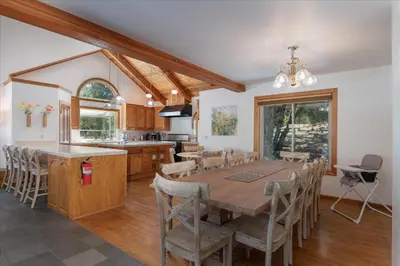a kitchen and dining room with a wooden table and chairs at Greystone Manor- HUGE home with sleeping for 21 in Oakhurst