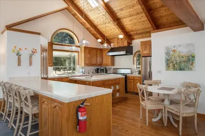 a kitchen with wooden cabinets and a large island with a counter top at Greystone Manor- HUGE home with sleeping for 21 in Oakhurst
