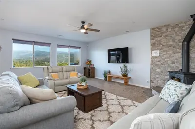 a living room with two couches and a fireplace at Hilltop Paradise with stunning views/hot tub/firepit/dog friendly in Oakhurst