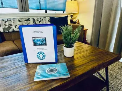 a laptop on a wooden table with a potted plant at Inside Yosemite Park-Cozy Corner Unit-Sleeps 2 in Yosemite West