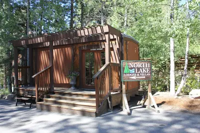 a small wooden cabin with a sign in front of it at North Lake Lodges & Villas in Incline Village