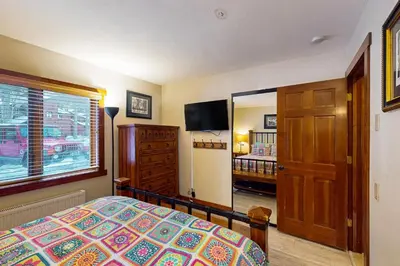 a bedroom with a bed and a window and a mirror at Meadow Ridge 44 in Mammoth Lakes
