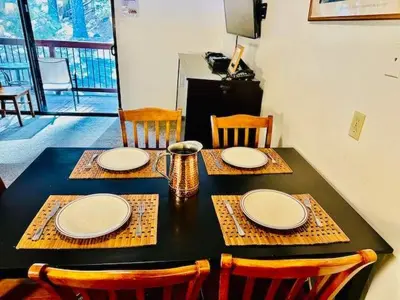 a black table with chairs and plates on it at Treetop Condo in Yosemite-Sleeps 6-Balcony in Yosemite West