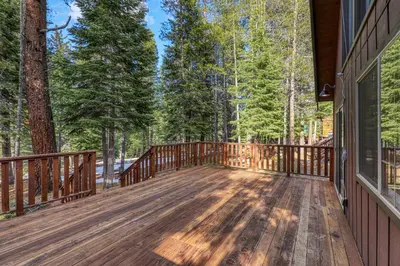 a large wooden deck on the side of a house at Donner Gem by Tahoe Getaways - Beautifully Updated, Hot Tub, Pet Friendly in Truckee